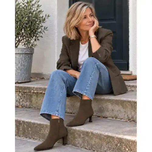 Frau in Jeans und Tweedblazer trägt braune Stiefeletten mit Kitten Heel aus Wildleder