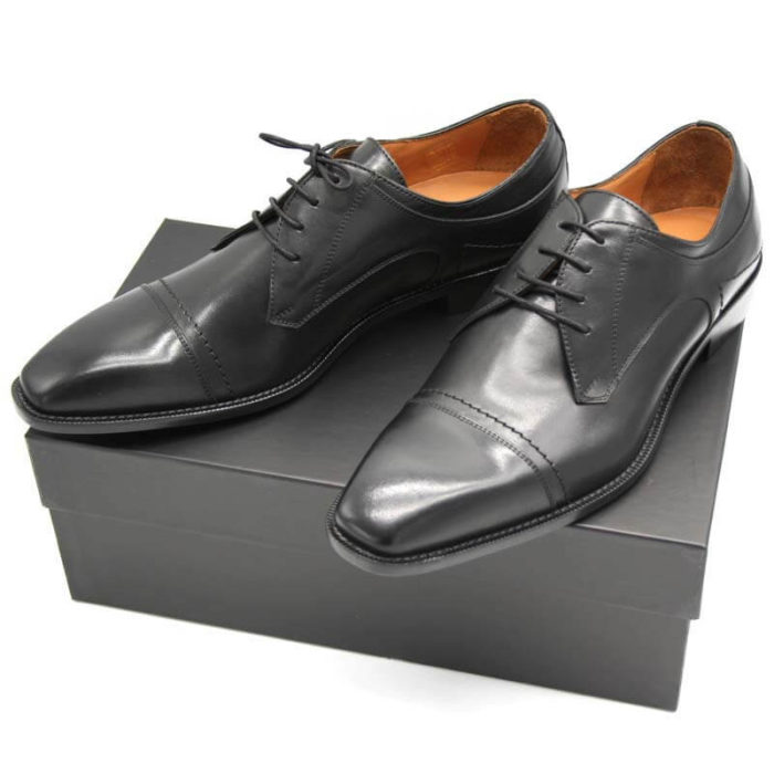 Foto Italienische Herrenschuhe schwarz mit Zehenkappe und markanter Sohle auf schwarzem Schuhkarton_Modell 112