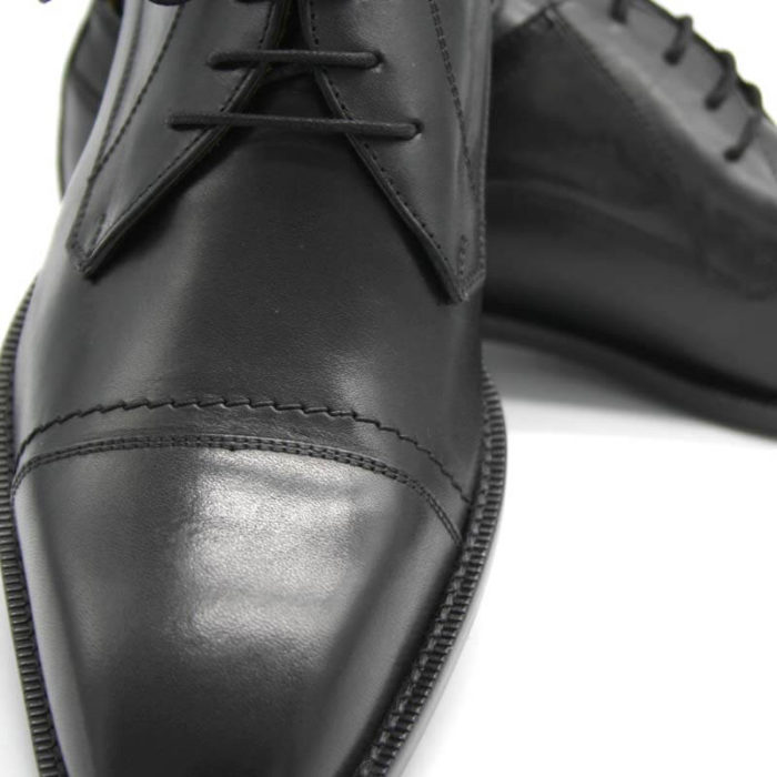 Foto Nahaufnahme Italienische Herrenschuhe schwarz mit Zehenkappe und markanter Sohle. Der rechte Schuh zeigt nach vorn und ist auf dem Linken abgestützt, der nach rechts zeigt_Modell 112