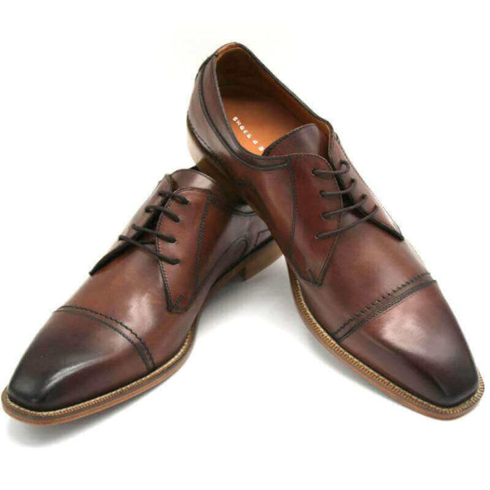 Foto Individuell und maskulin Herrenschuh Business Derby in Cognac. 2 Schuhe nach vorne zeigend; einer auf den anderen abgestützt.