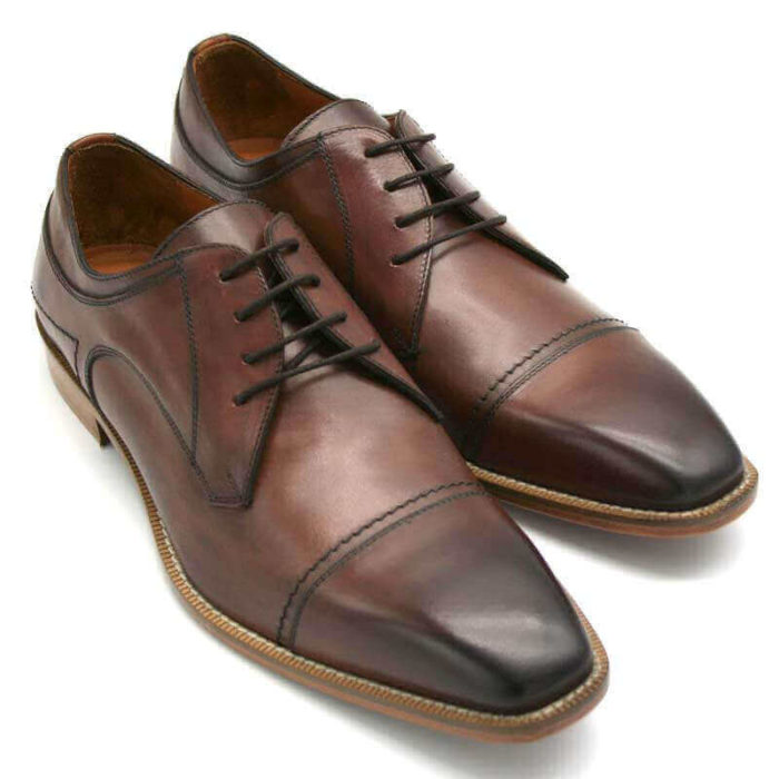 Foto Individuell und maskulin Herrenschuh Business Derby in Cognac. 2 Schuhe nach vorne zeigend; einer auf den anderen abgestützt.