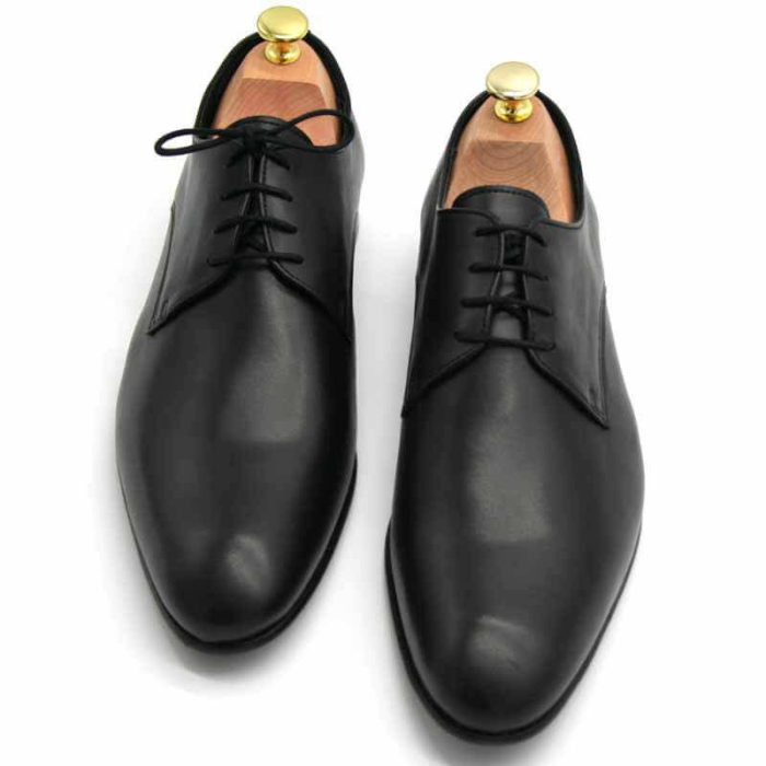 Foto von zwei schwarzen Herrenschuhen beide mit Schuhspannern mit goldenem Knauf, nach vorne weisend - Modell Alltagsfavorit 304