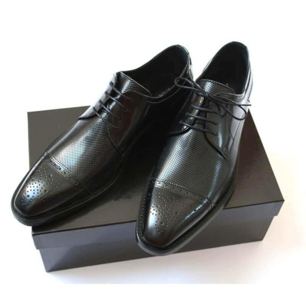 Foto-Schwarzer Halfbrogue Business Schuh mit Perforation. Ansehnlich und stilvoll. 2 Schuhe auf schwarzem Schuhkarton.