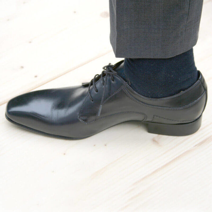 Foto 1 schwarzee Herrenschuh Elegant und schlicht Glattleder nach links zeigend mit sichtbarer Socke und Hosenbein.