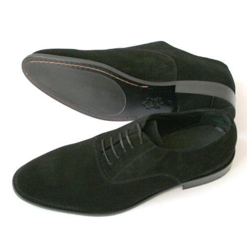 Foto von zwei schwarzen Wildleder Oxford Herrenschuhen nach links zeigend - ein Schuh liegt auf der Seite, so dass die Sohle zu sehen ist. Modell Herren Oxford