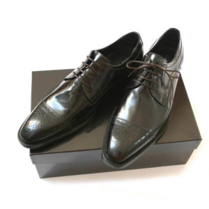 Foto Repräsentative Eleganz. Eleganter Halfbrogue Business Schuh. 2 Schuhe auf schwarzem Schuhkarton.