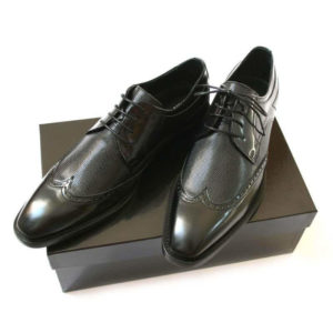 Foto Weltmännischer Schnürer. Eleganter Derby Business Schuh mit Muster. 2 Schuhe auf schwarzem Schuhkarton.