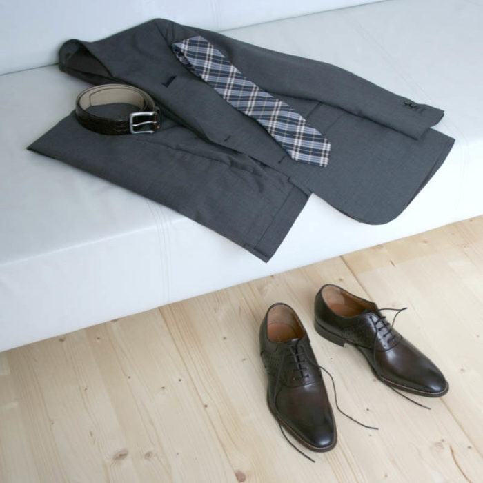 Men`s business shoes-Discreet fashionable-Oxford_with hole pattern_mocha brown_2 shoes in combination with a gray suit on a couch