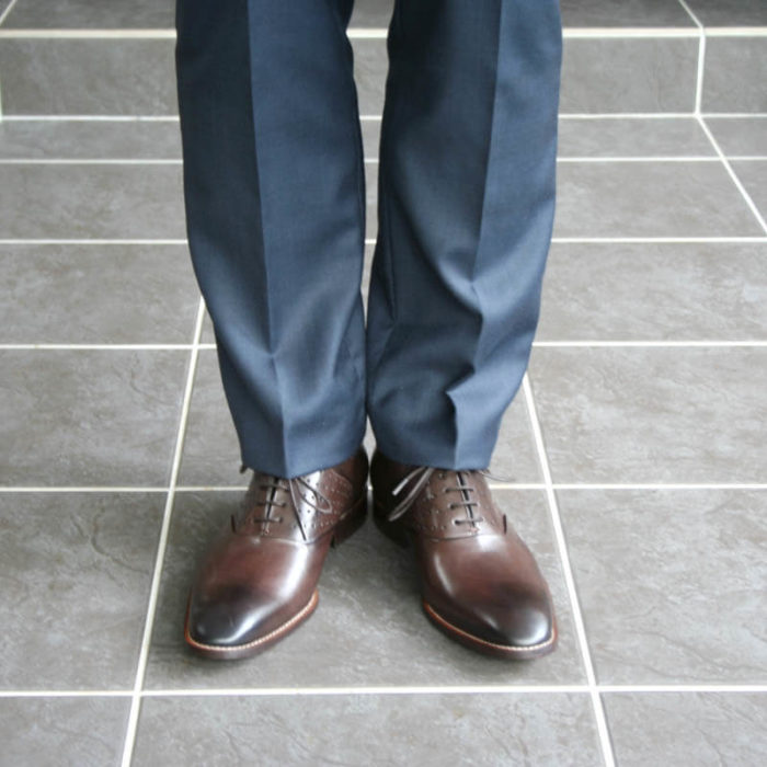 Men`s business shoes-Discreet fashionable-Oxford_with hole pattern_mocha brown_2 shoes with blue suit - only legs - front view