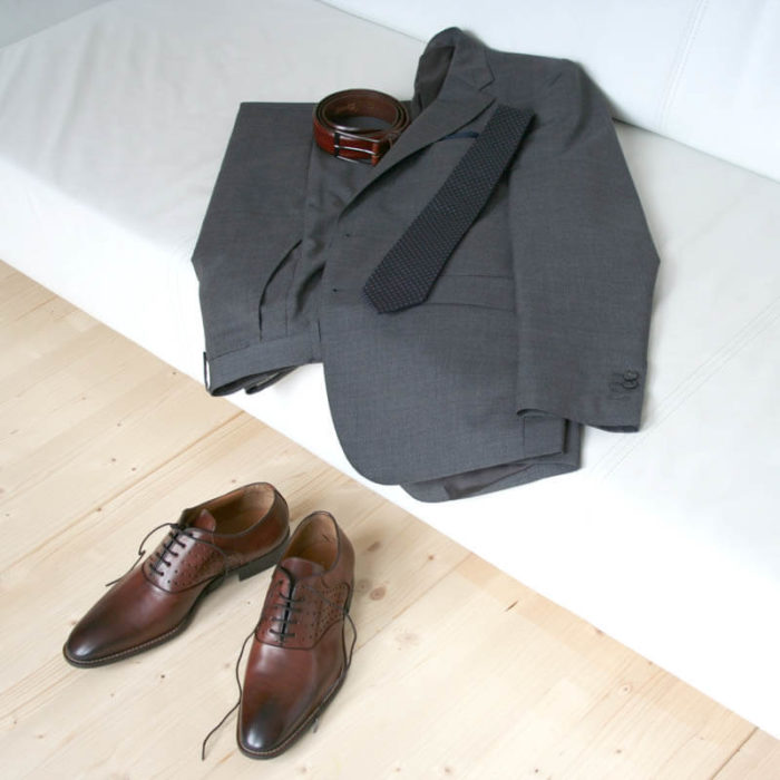 Photo-Men`s business shohes-Sporty elegant-_Oxford_in Cognac with hole pattern_2 shoes with a dark gray suit on a couch