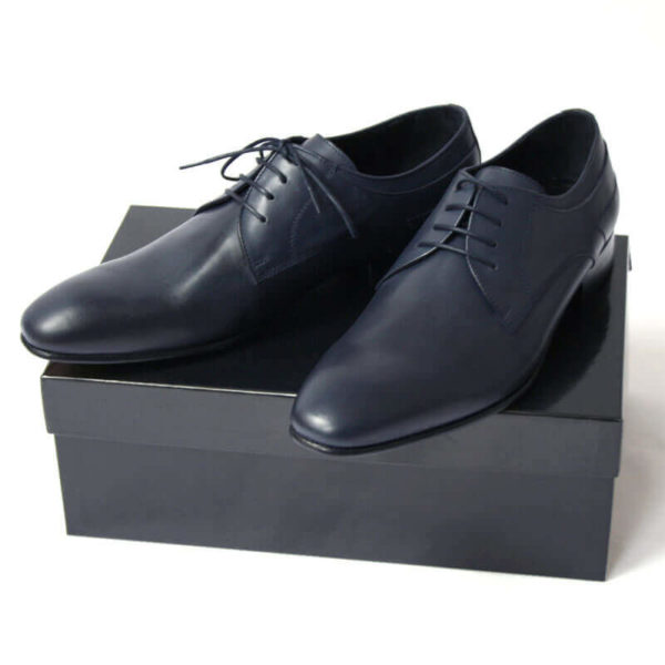 Foto von zwei dunkelblauen Glattleder Derby Herrenschuhen auf schwarzem Schuhkarton. Modell Stadt Eleganz