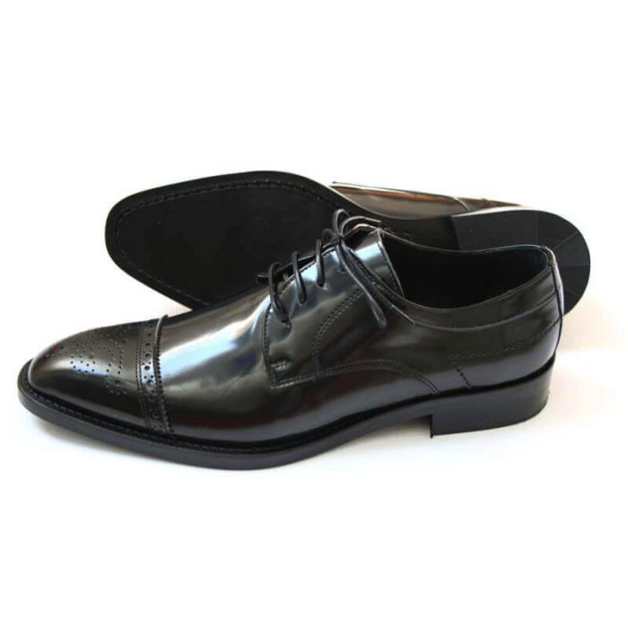 Foto-Herren Business Schuhe-Halfbrogue. 1 Schuh zeigt nach links mit der Spitze, der andere liegt, so dass die Sohle zu sehen ist.